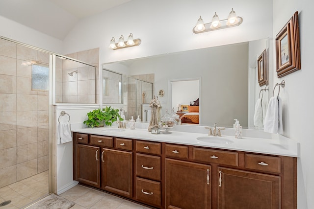 bathroom with a sink, vaulted ceiling, tile patterned flooring, a shower stall, and ensuite bath