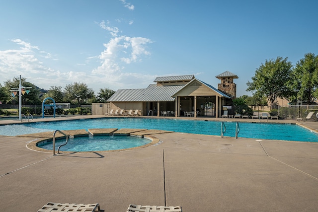 pool featuring fence, a hot tub, and a patio area