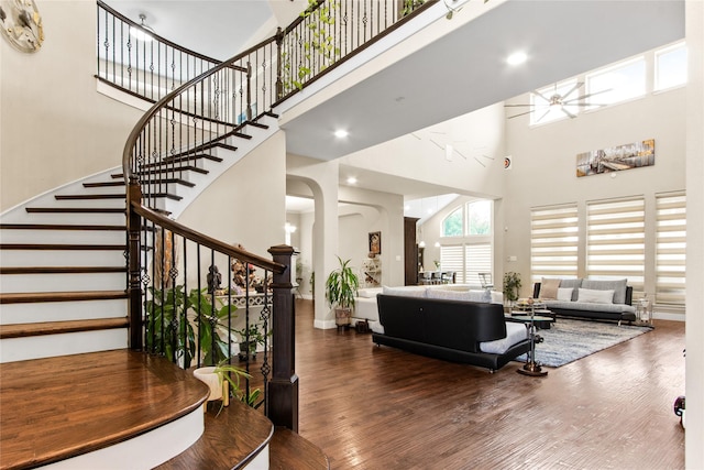13043 Seattle Slew St, Frisco, TX 75035 - living room featuring a towering ceiling, wood finished floors, stairway, ceiling fan, and baseboards