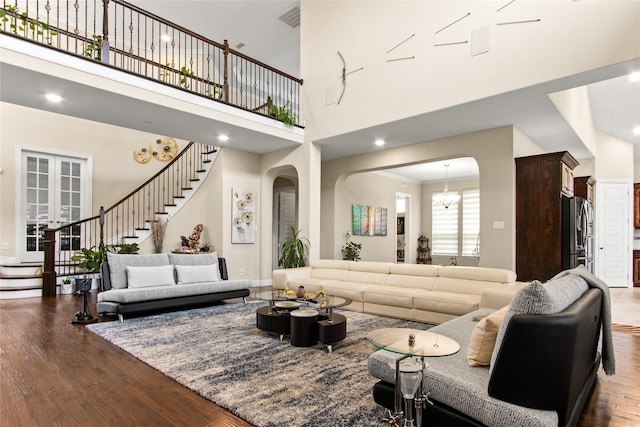 13043 Seattle Slew St, Frisco, TX 75035 - living area featuring stairway, arched walkways, wood finished floors, and a high ceiling
