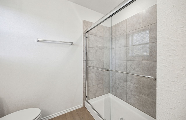 1055 Clear Dusk Ln, Forney, TX 75126 - bathroom featuring a stall shower, wood finished floors, toilet, and baseboards