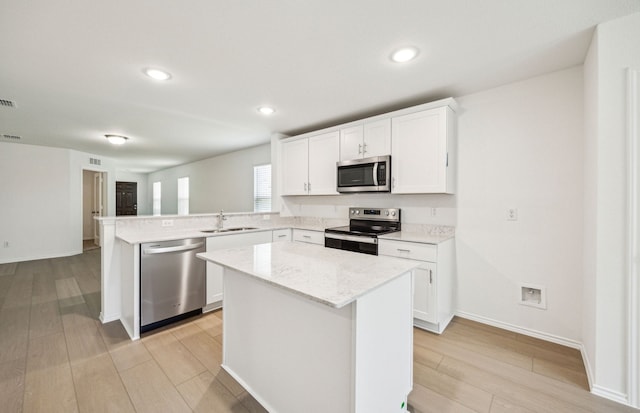 1055 Clear Dusk Ln, Forney, TX 75126 - kitchen with stainless steel appliances, a sink, light wood-style flooring, a peninsula, and a center island