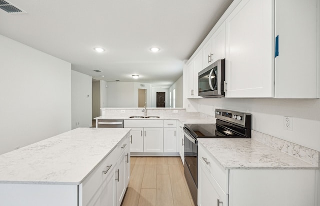 1055 Clear Dusk Ln, Forney, TX 75126 - kitchen with appliances with stainless steel finishes, a sink, recessed lighting, a peninsula, and light wood finished floors