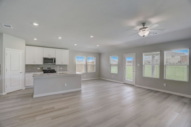 610 Willet Dr, Mckinney, TX 75069 - kitchen featuring visible vents, backsplash, open floor plan, white cabinets, and appliances with stainless steel finishes