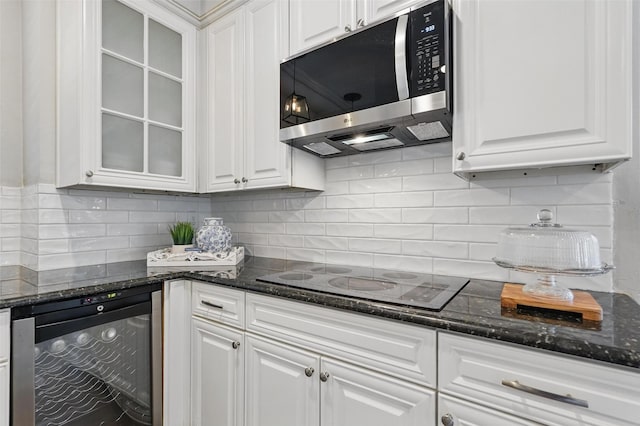 1102 Belvedere Dr, Allen, TX 75013 - kitchen featuring black electric stovetop, beverage cooler, stainless steel microwave, and white cabinetry