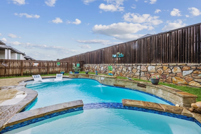 view of swimming pool with a fenced backyard and a pool with connected hot tub