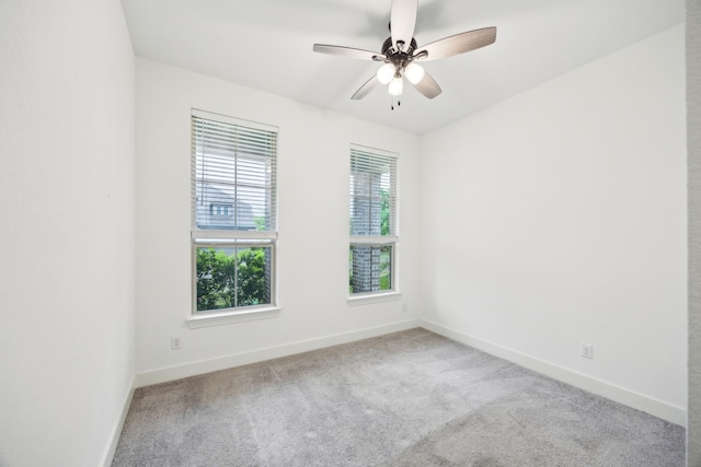 carpeted spare room with baseboards and ceiling fan