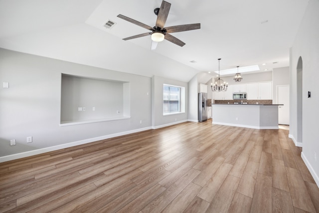 unfurnished living room featuring light wood-style floors, lofted ceiling, visible vents, and ceiling fan with notable chandelier