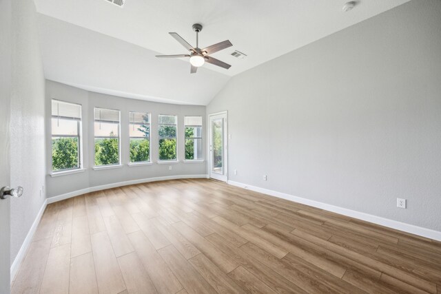 spare room with wood finished floors, a ceiling fan, baseboards, and vaulted ceiling
