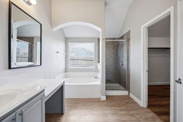 full bath with a shower stall, a walk in closet, and vanity