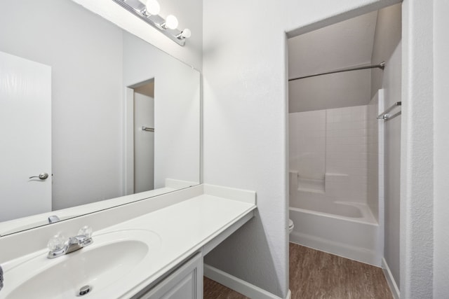 bathroom with wood finished floors, vanity, bathtub / shower combination, baseboards, and toilet