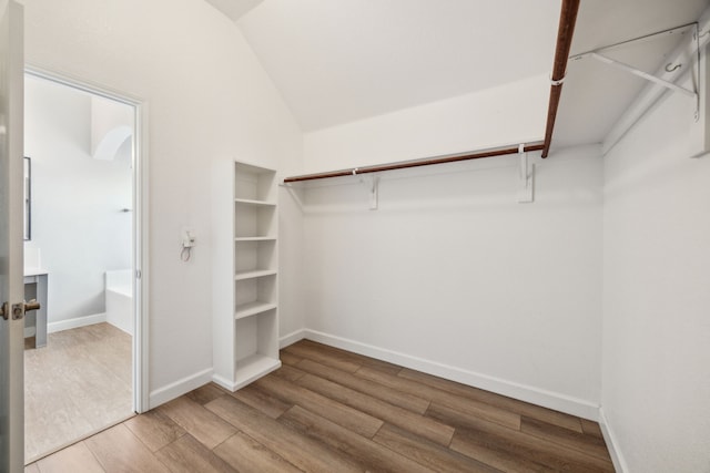 spacious closet featuring lofted ceiling and wood finished floors