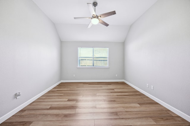 empty room featuring vaulted ceiling, a ceiling fan, and light wood-type flooring