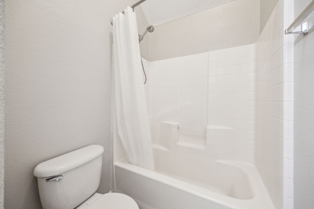 full bath with a textured wall, toilet, and shower / bathtub combination with curtain