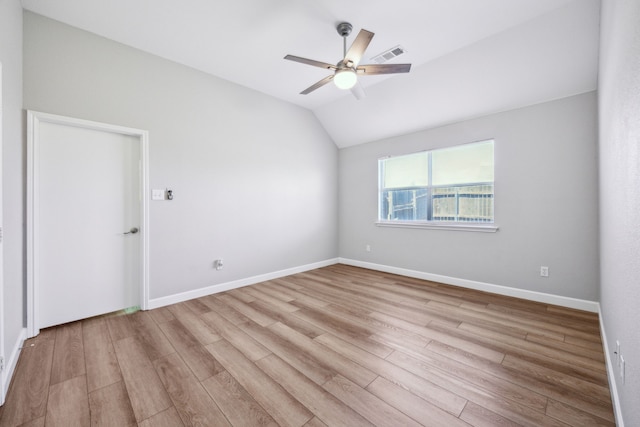 spare room with baseboards, visible vents, lofted ceiling, wood finished floors, and ceiling fan