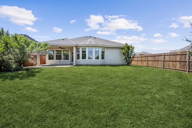 rear view of house with a patio area, a yard, a ceiling fan, and a fenced backyard