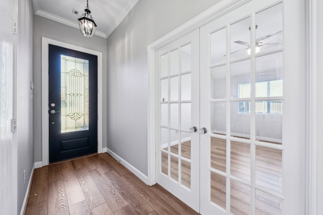 foyer with ceiling fan, baseboards, ornamental molding, and wood finished floors