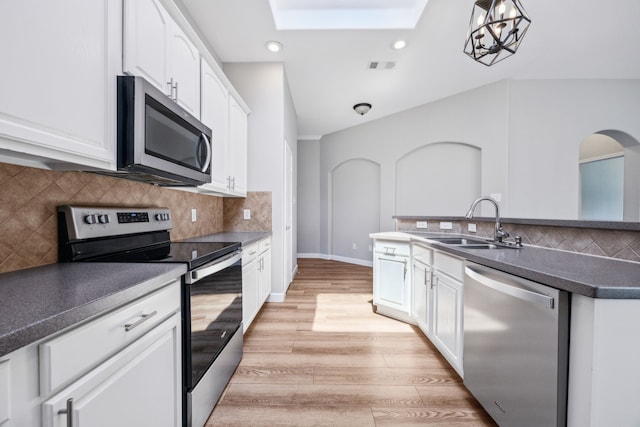 kitchen with a sink, a skylight, stainless steel appliances, visible vents, and recessed lighting