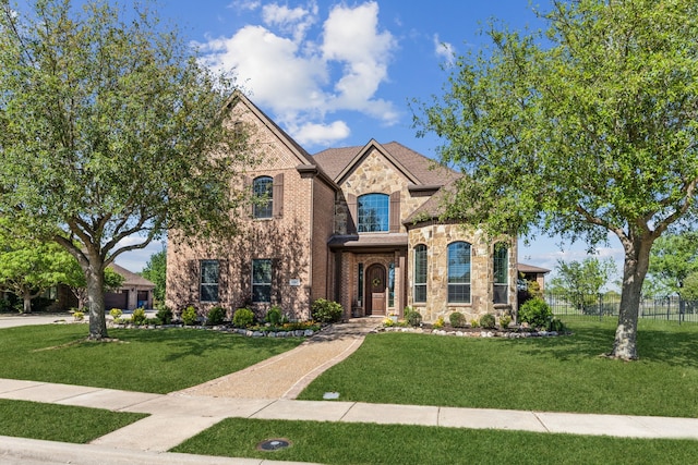 french country inspired facade featuring stone siding and brick siding