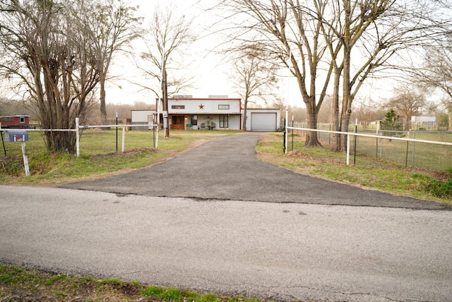 view of front of home featuring fence, a garage, a front lawn, and aphalt driveway