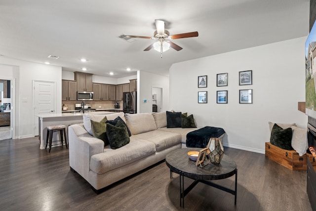 living area featuring ceiling fan, baseboards, and dark wood-style floors