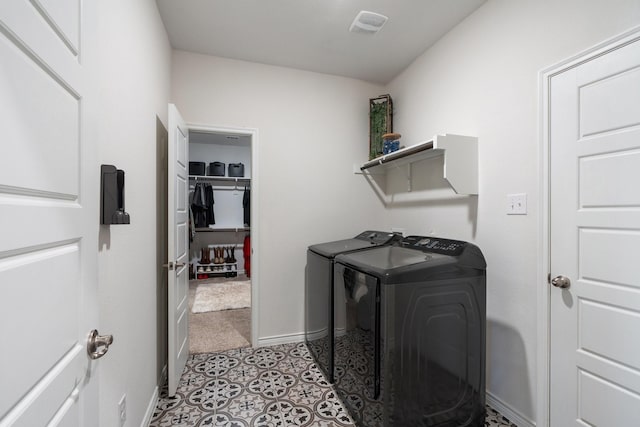 laundry room with washing machine and dryer, visible vents, baseboards, and laundry area