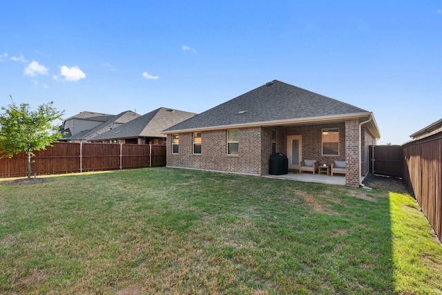rear view of property with a lawn, a fenced backyard, a patio, brick siding, and roof with shingles
