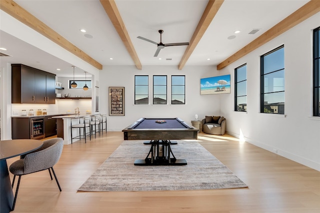 playroom with light wood finished floors, beamed ceiling, a ceiling fan, indoor wet bar, and pool table