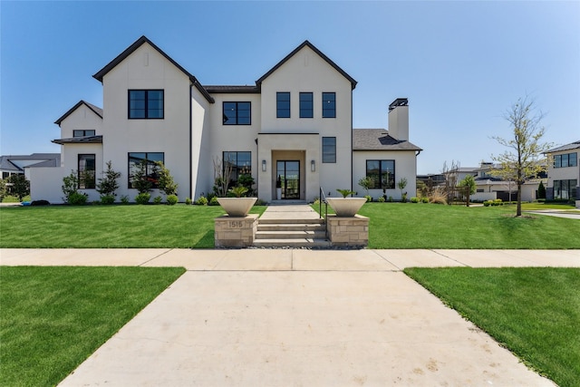 modern inspired farmhouse with a chimney, stucco siding, and a front yard