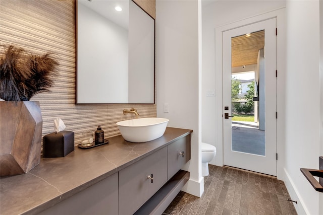 bathroom with recessed lighting, backsplash, toilet, vanity, and baseboards