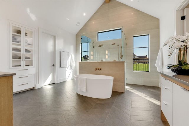 bathroom featuring recessed lighting, a freestanding tub, vanity, and tiled shower