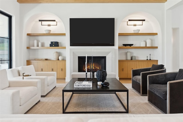 living area with a warm lit fireplace and built in shelves