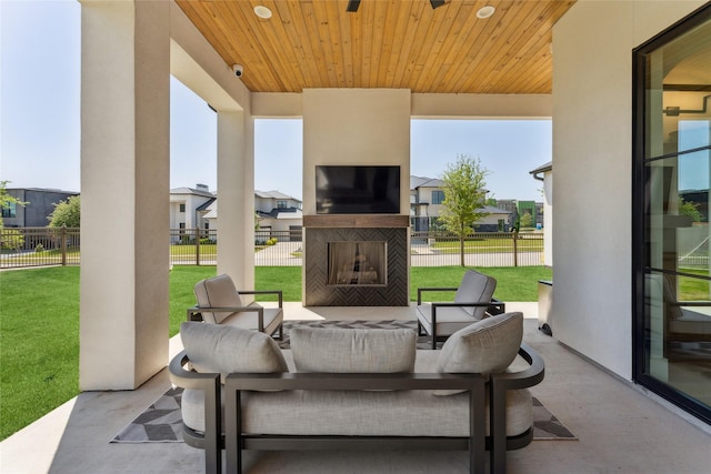 view of patio / terrace with fence, an outdoor living space with a fireplace, and a residential view