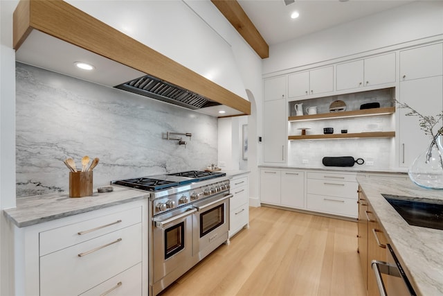 kitchen with open shelves, double oven range, premium range hood, backsplash, and light stone countertops