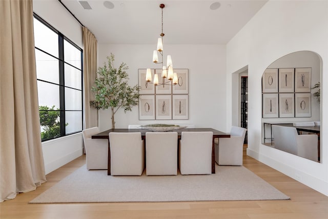 dining space featuring light wood finished floors, visible vents, and a chandelier