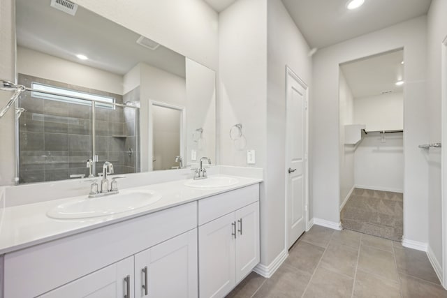 bathroom with a sink, double vanity, a stall shower, visible vents, and recessed lighting