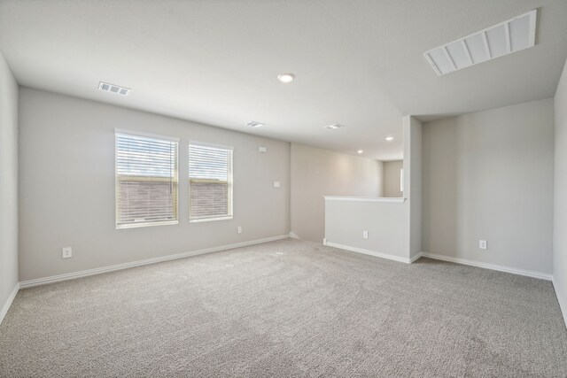carpeted empty room featuring recessed lighting, visible vents, and baseboards