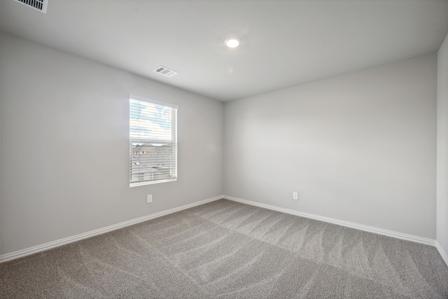 carpeted empty room with baseboards and visible vents