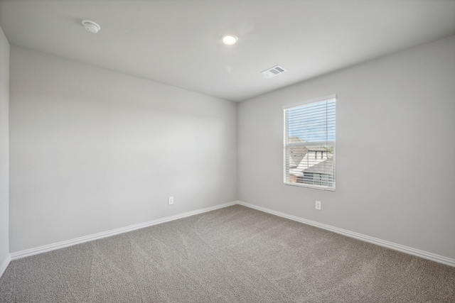 carpeted empty room featuring baseboards, visible vents, and recessed lighting