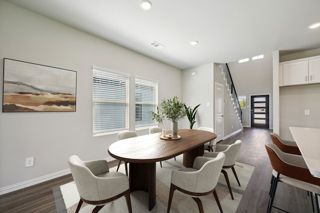 dining area featuring baseboards, a healthy amount of sunlight, and dark wood-style flooring