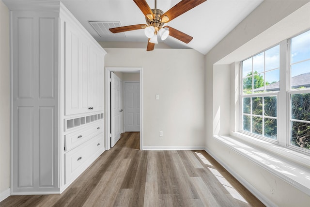unfurnished bedroom featuring baseboards, a ceiling fan, wood finished floors, and visible vents