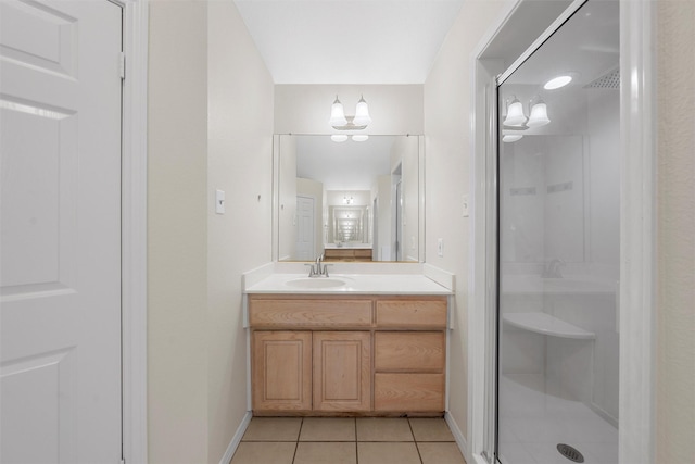 bathroom featuring tile patterned floors, baseboards, an inviting chandelier, a shower stall, and vanity