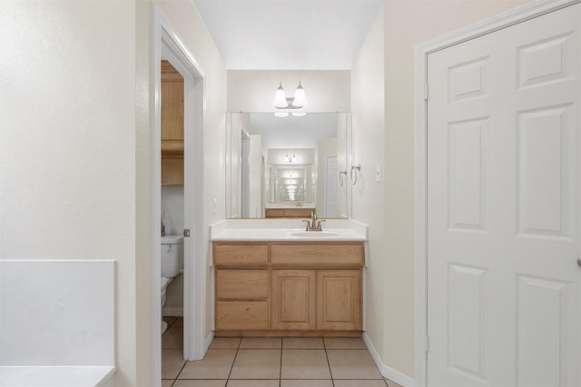 bathroom with tile patterned floors, toilet, baseboards, an inviting chandelier, and vanity