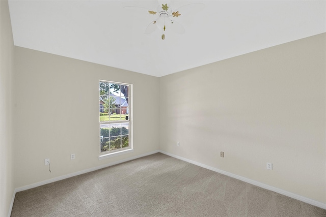 spare room featuring light carpet and baseboards