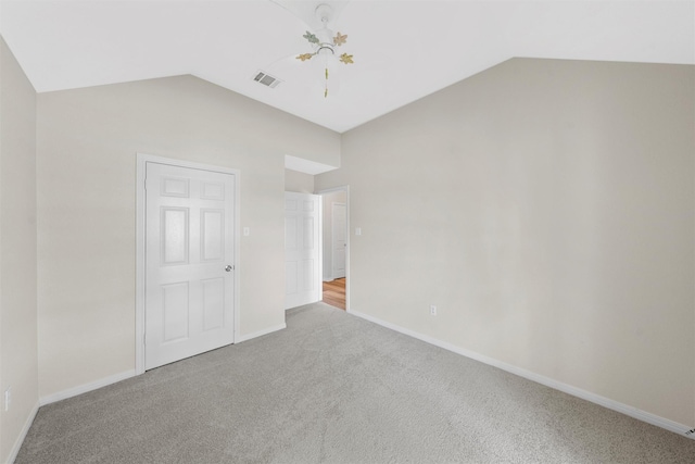 unfurnished bedroom with lofted ceiling, baseboards, visible vents, and carpet floors