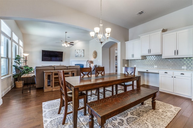560 Southwestern Dr, Rockwall, TX 75087 - dining space with arched walkways, a ceiling fan, dark wood-style flooring, a fireplace, and a chandelier