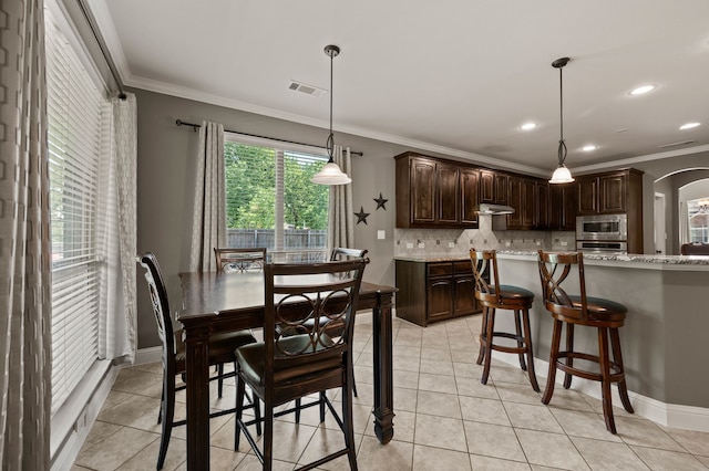 dining area featuring recessed lighting, visible vents, ornamental molding, light tile patterned floors, and arched walkways