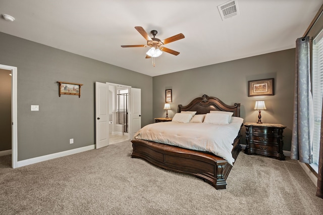carpeted bedroom featuring ensuite bath, ceiling fan, baseboards, and visible vents