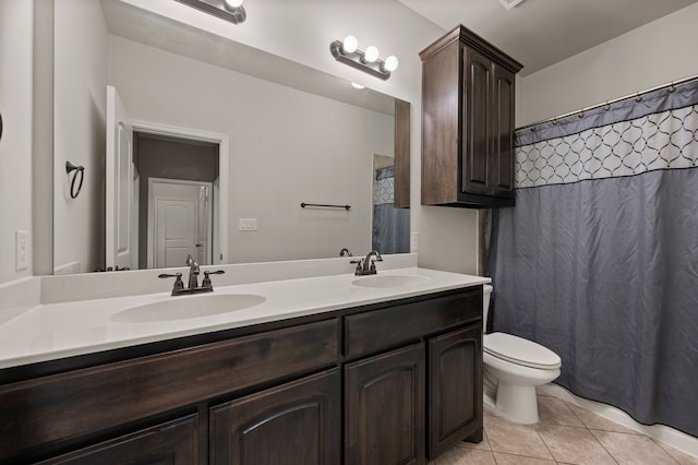 bathroom with toilet, tile patterned flooring, a sink, and double vanity
