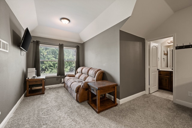 sitting room featuring lofted ceiling, baseboards, and light colored carpet